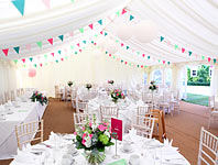 Colourful bunting strung across the roof of a marquee